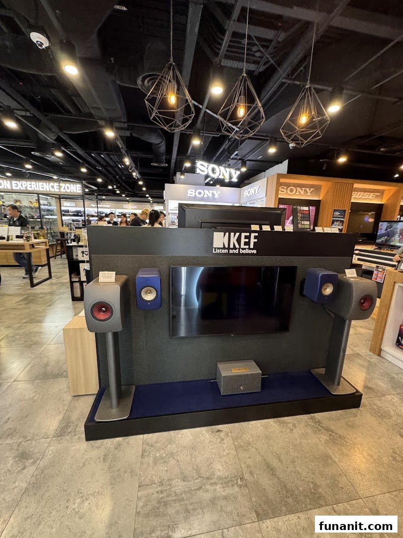 A KEF audio display featuring high-fidelity speakers and a screen, showcasing premium sound equipment in an electronics store.