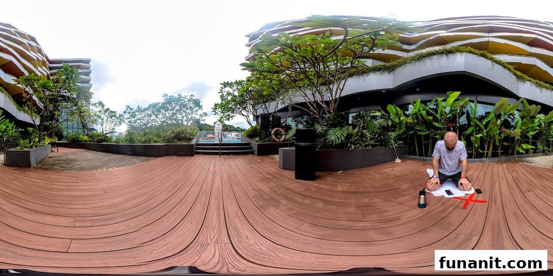 A person exercising on a spacious outdoor wooden deck surrounded by lush greenery and modern architecture.