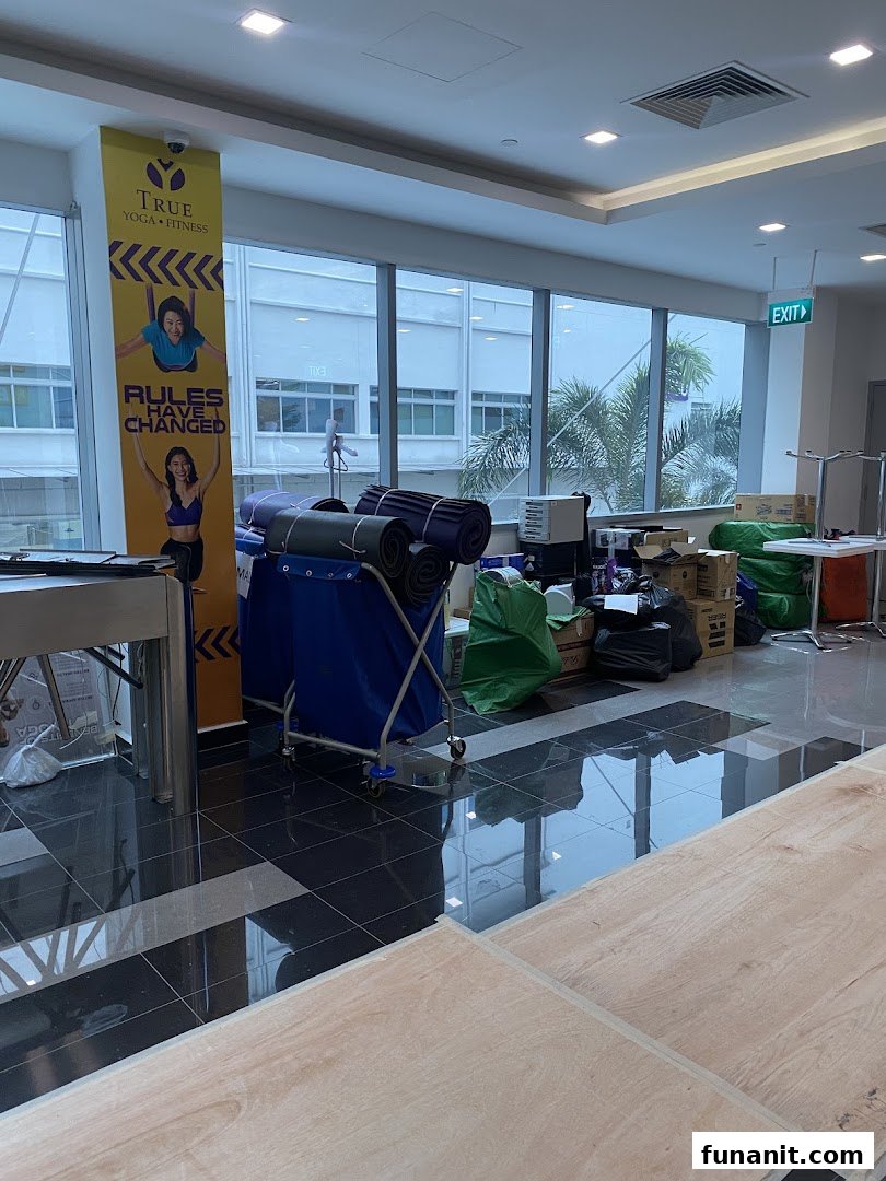 Interior view of a fitness center with a 'True Yoga + Fitness' banner and rolled yoga mats.