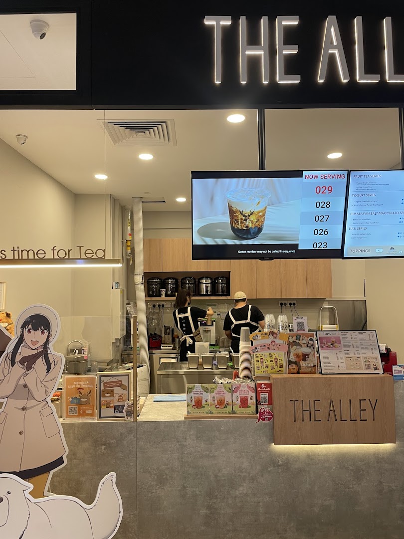 An interior shot of The Alley bubble tea shop, showing the counter, staff, and digital menu.