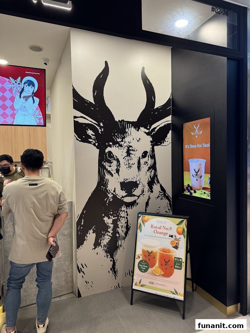 The shop front of The Alley featuring a large deer graphic, a promotional A-frame, and a customer.