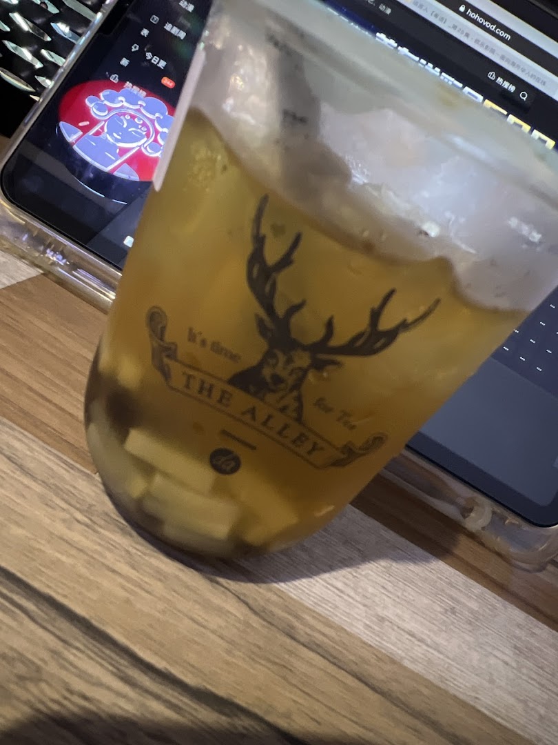 A refreshing iced drink from The Alley, featuring its distinctive deer logo and visible toppings.