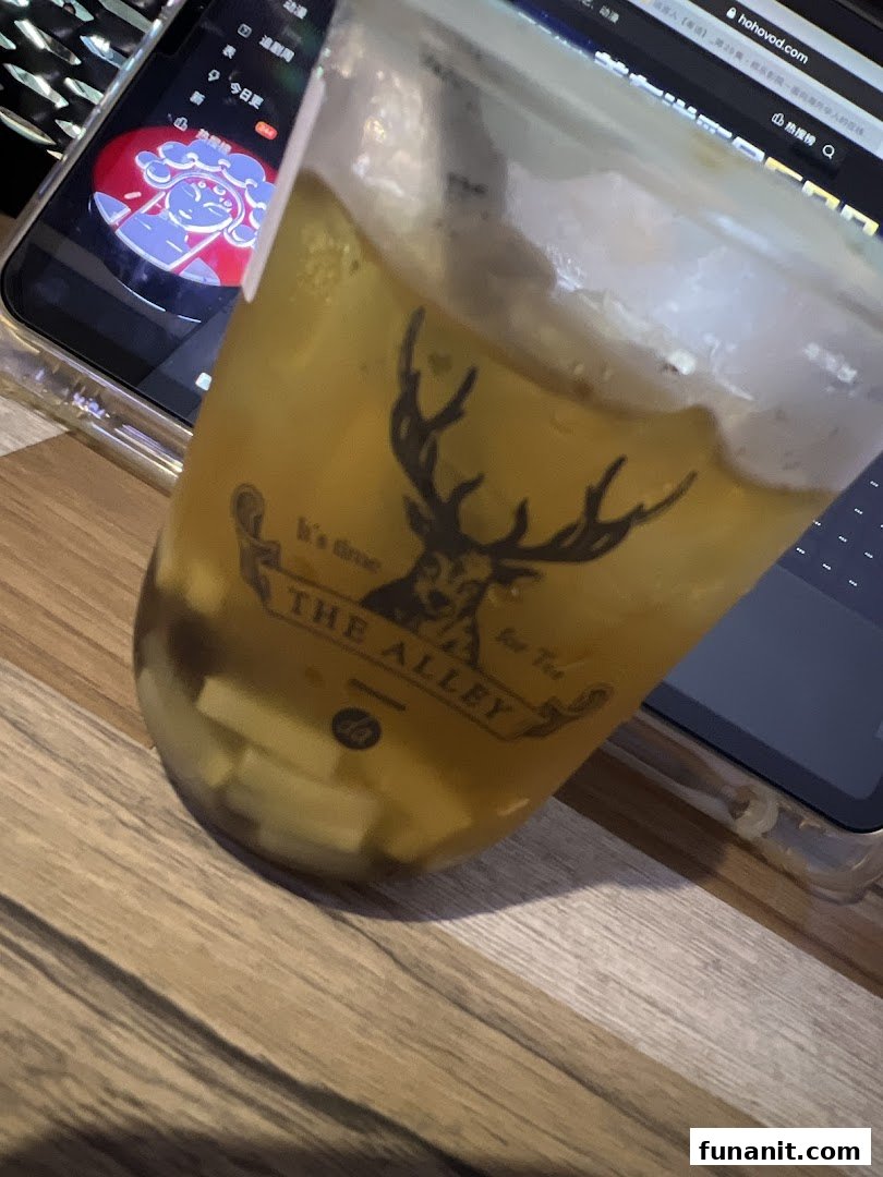 A refreshing iced drink from The Alley, featuring its distinctive deer logo and visible toppings.