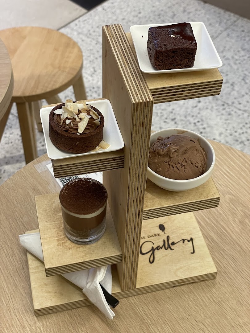A delightful chocolate dessert platter featuring a brownie, tart, ice cream, and shot.