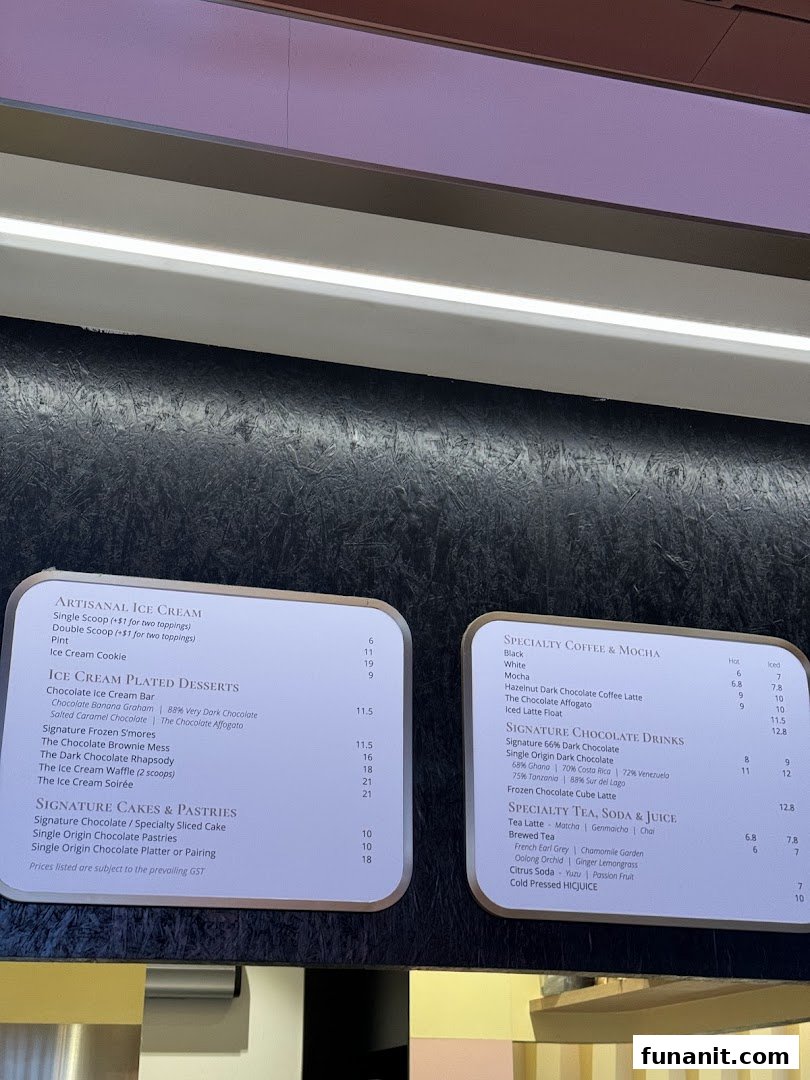 A detailed menu board displaying artisanal ice cream, plated desserts, cakes, pastries, coffee, chocolate drinks, teas, sodas, and juices.