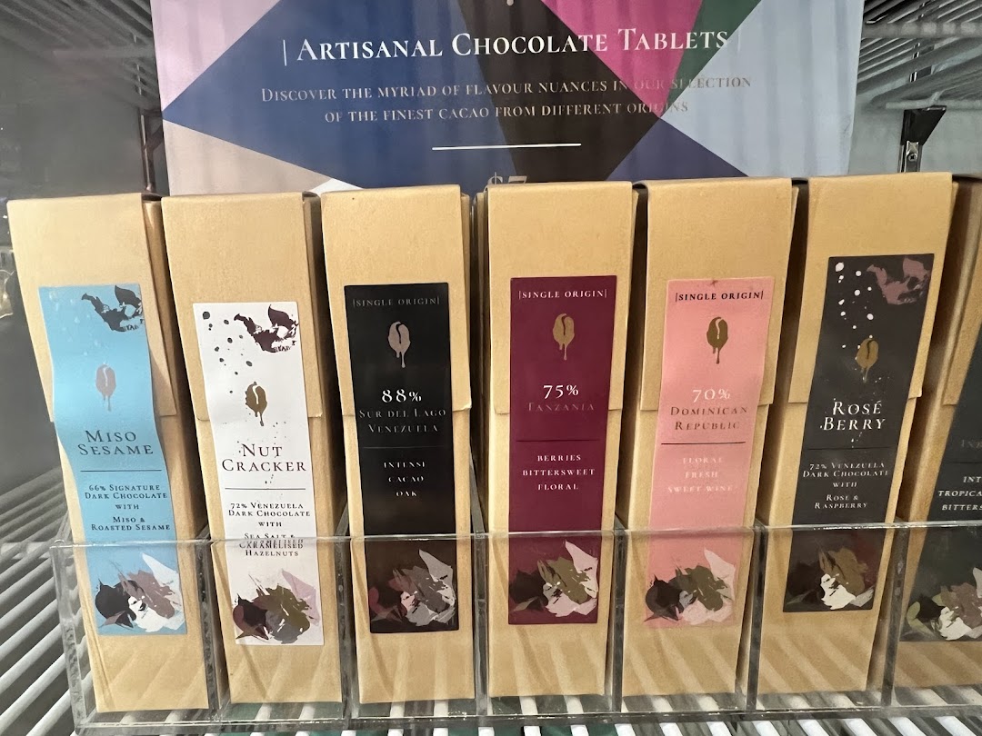 A display of artisanal chocolate tablets from The Dark Gallery, showcasing various unique flavors and origins.