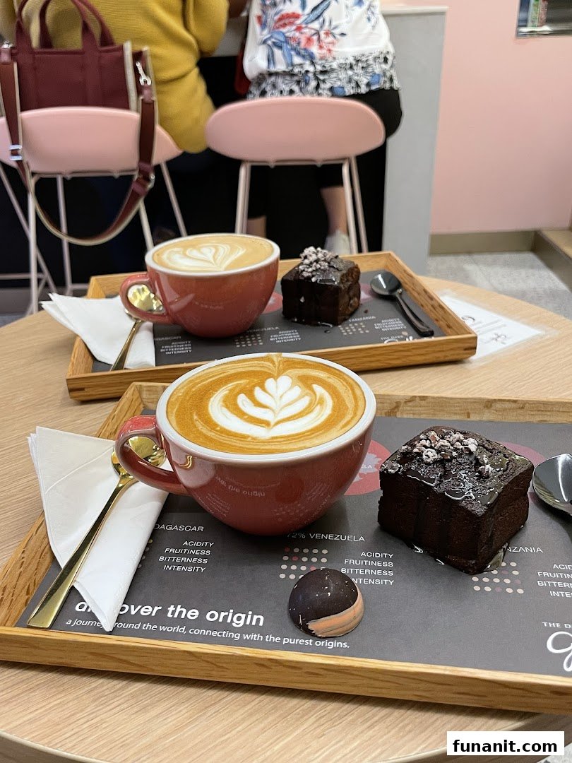 Two beautifully crafted lattes and chocolate desserts served on wooden trays.