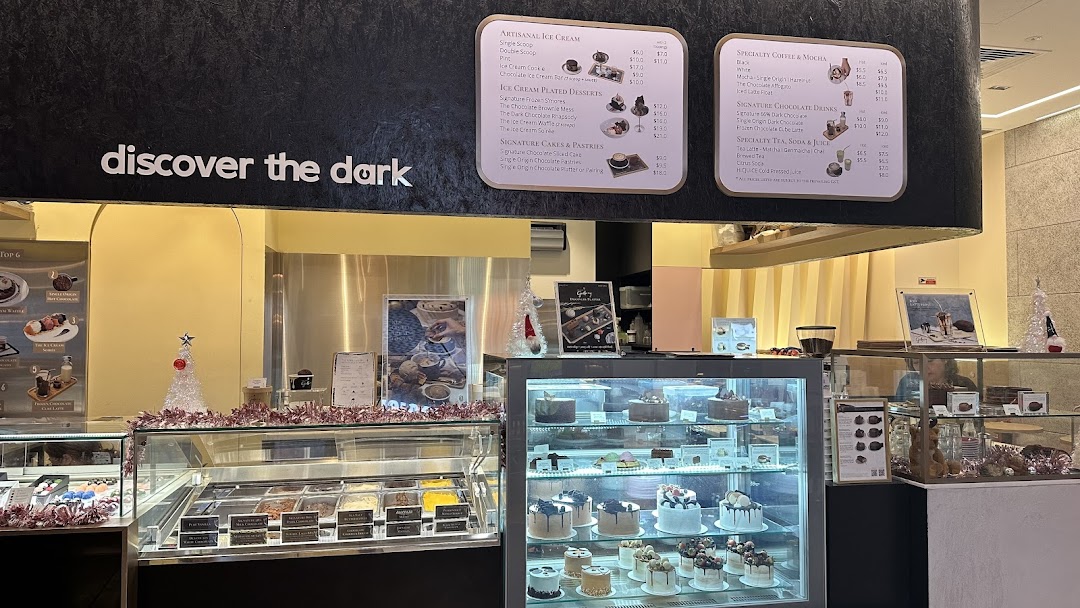 An inviting interior view of The Dark Gallery, showcasing ice cream, cakes, and menu boards.