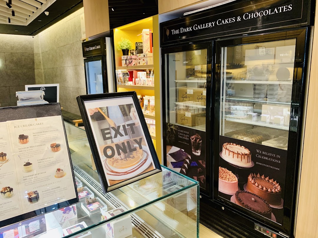 Interior view of The Dark Gallery, showcasing cakes, chocolates, and an ice cream cake menu.