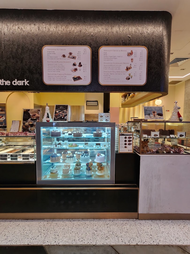 Interior view of The Dark Gallery, showcasing dessert displays, ice cream, and menu boards.