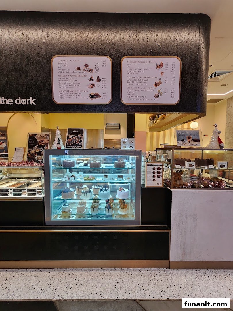 Interior view of The Dark Gallery, showcasing dessert displays, ice cream, and menu boards.