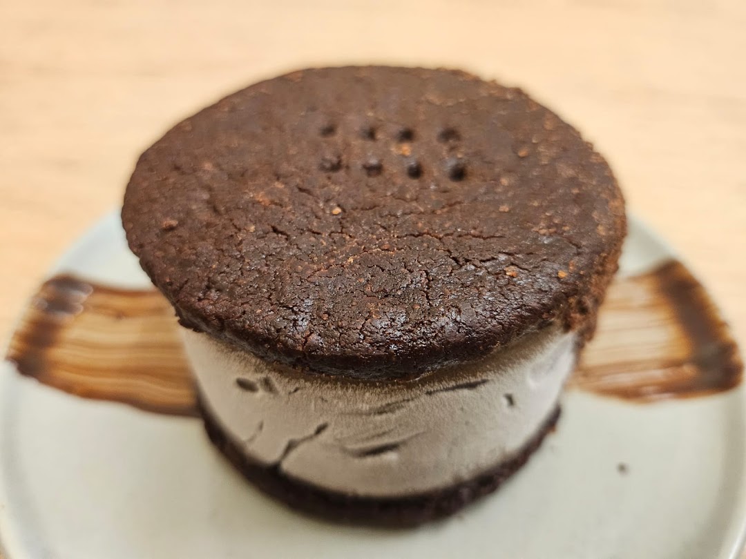 A delicious dark chocolate ice cream sandwich on a plate.