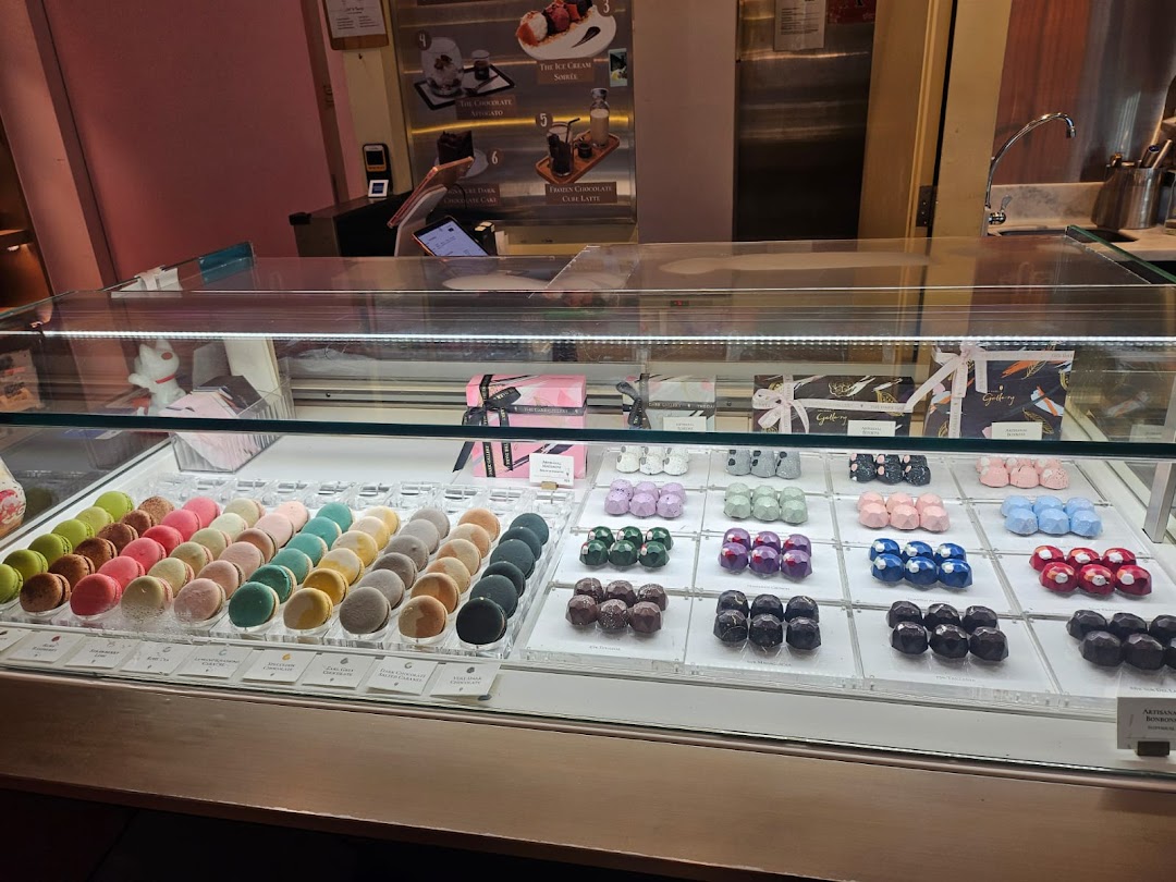 A vibrant display of macarons and artisanal chocolates in The Dark Gallery.