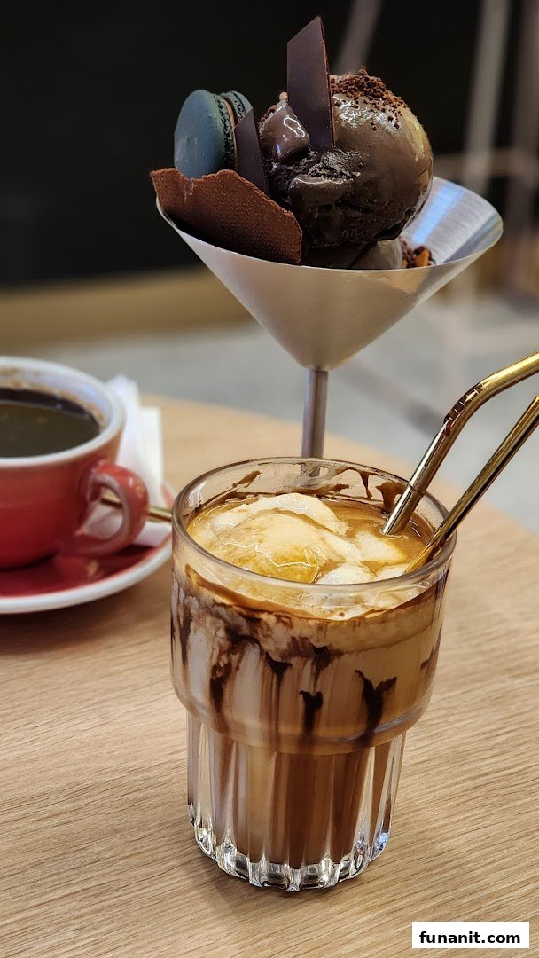 A decadent chocolate dessert, an iced coffee with ice cream, and a hot coffee on a wooden table.