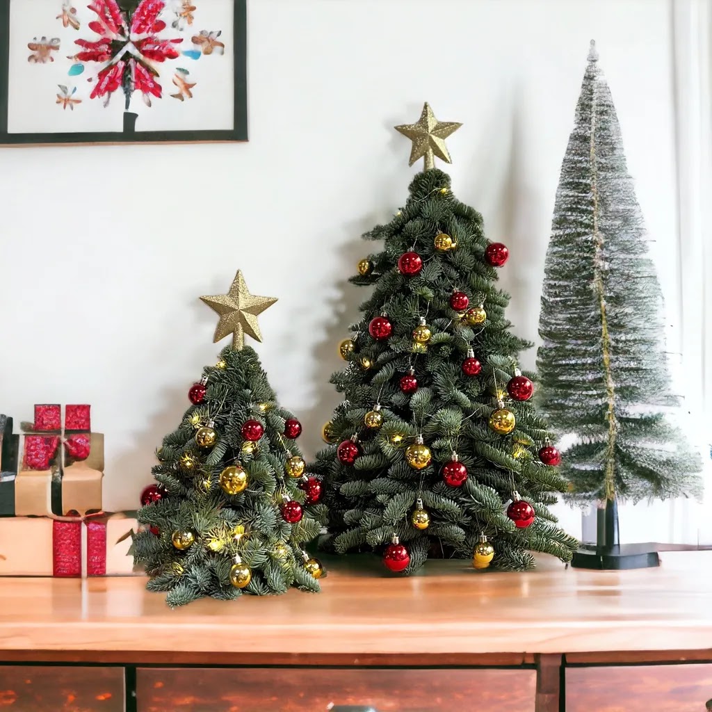 Three festive Christmas trees adorned with red and gold ornaments, displayed on a wooden surface.