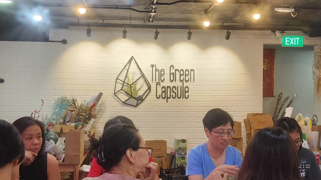 Interior view of The Green Capsule, featuring its logo, customers, and various plant-related products.