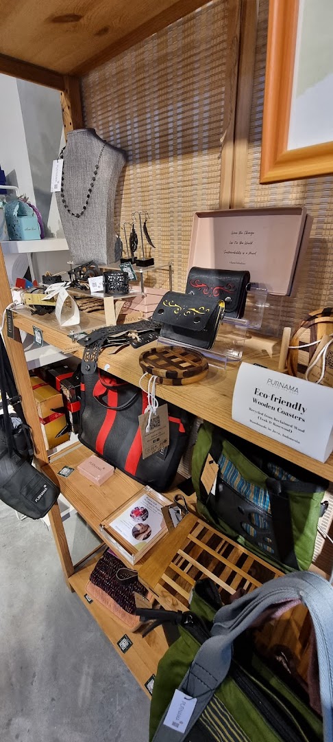 A wooden display shelf showcasing eco-friendly bags, accessories, and handcrafted wooden items.