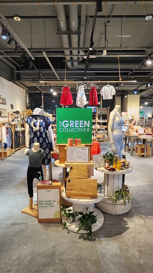 An interior shot of The Green Collective SG, featuring mannequins, clothing, and a central display.