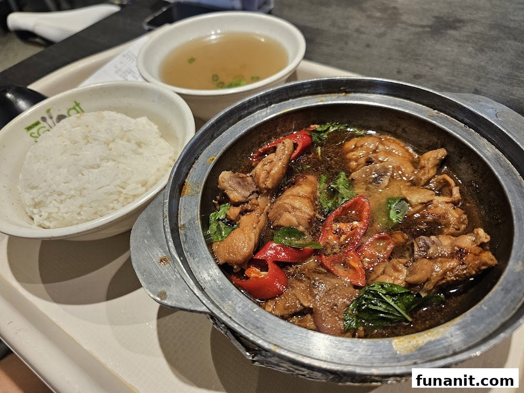 A delicious claypot chicken dish with rice and soup, served on a tray.