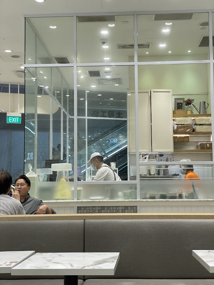 Interior view of Toast Box showing customers, staff, and the open kitchen area.