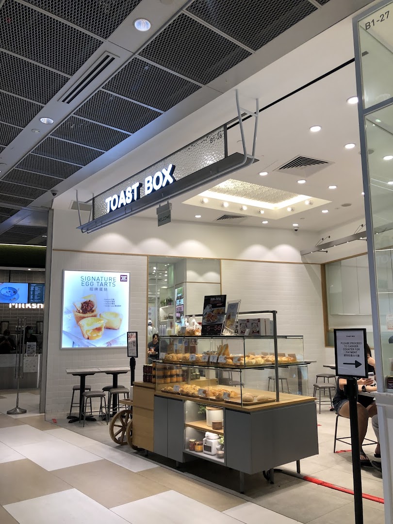 The Toast Box shopfront features a prominent sign, a tempting pastry display, and inviting seating.