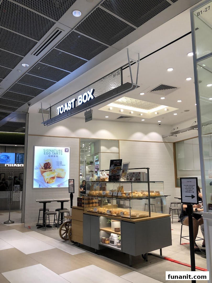 The Toast Box shopfront features a prominent sign, a tempting pastry display, and inviting seating.