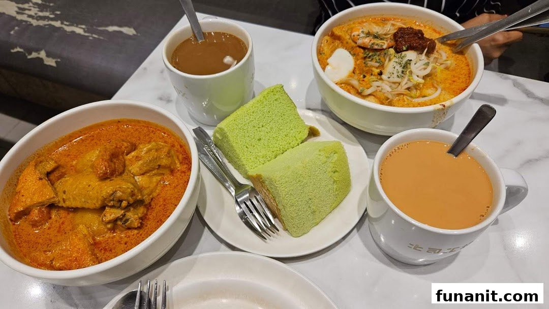 A table laden with delicious curry, laksa, pandan cake, and beverages at Toast Box.