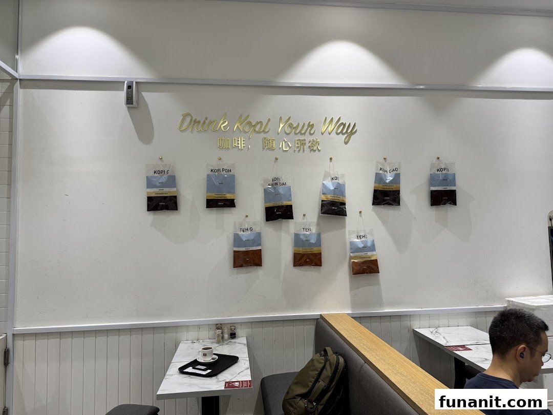 Interior view of Toast Box Funan, featuring a 'Drink Kopi Your Way' wall display and seating.