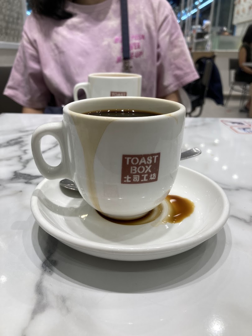 A close-up of a classic Kopi O from Toast Box on a marble table.