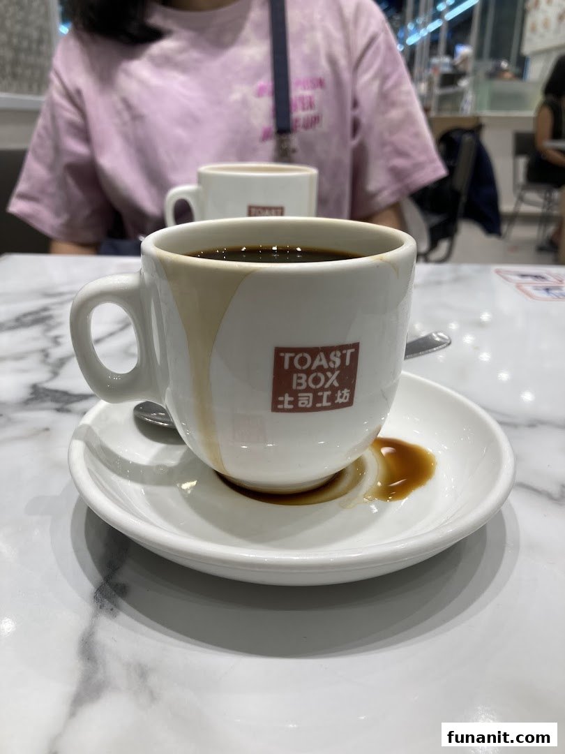A close-up of a classic Kopi O from Toast Box on a marble table.