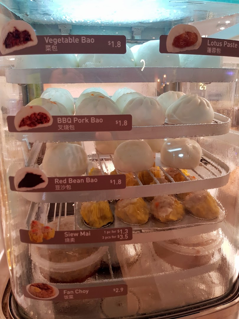 A display case showcasing various steamed buns and dim sum items with their prices.
