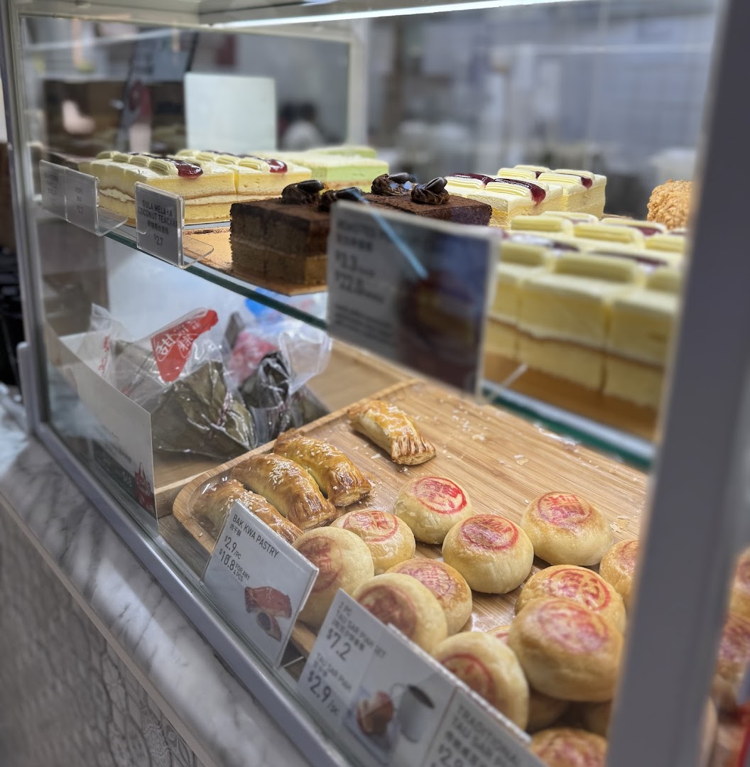 A vibrant display case showcasing a variety of cakes, pastries, and traditional snacks at Toast Box.