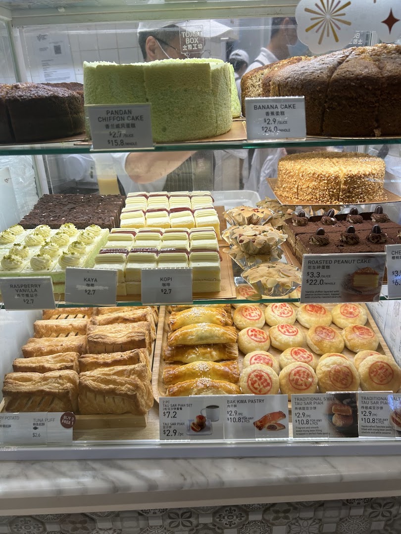A vibrant display case showcasing a variety of freshly baked cakes, pastries, and traditional local delights.