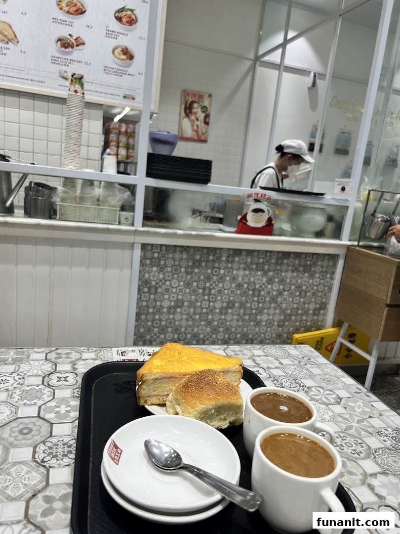 A tray with toast, a bun, and two cups of coffee on a patterned table inside Toast Box.