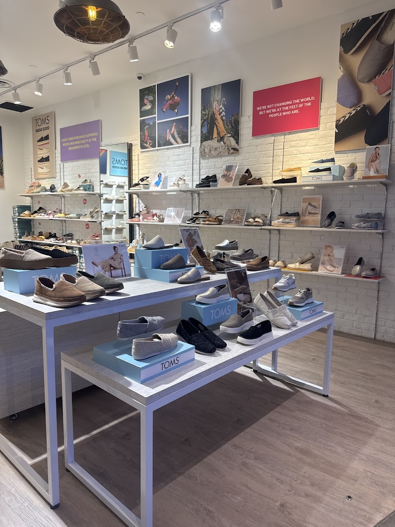 Interior view of Toms shoe store, showcasing various styles of footwear on display.
