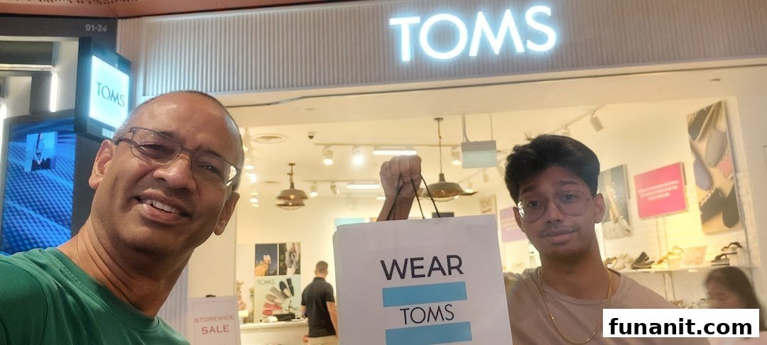 Two happy shoppers pose with their new TOMS bag in front of the TOMS store at Funan.