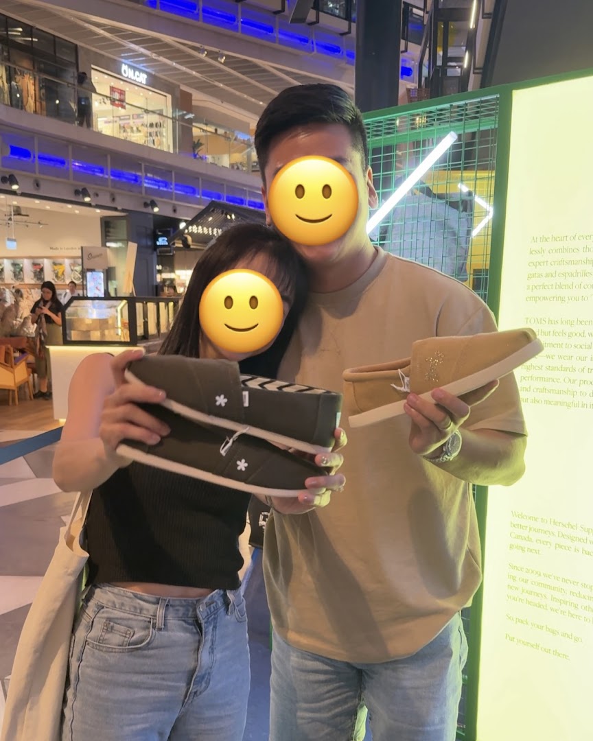 Two shoppers happily display their new TOMS shoes inside the vibrant Funan mall.