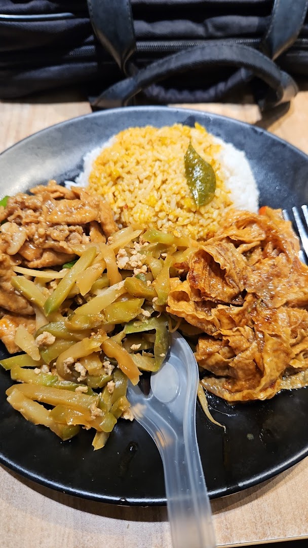 A plate of mixed vegetable rice with various toppings and a plastic fork.