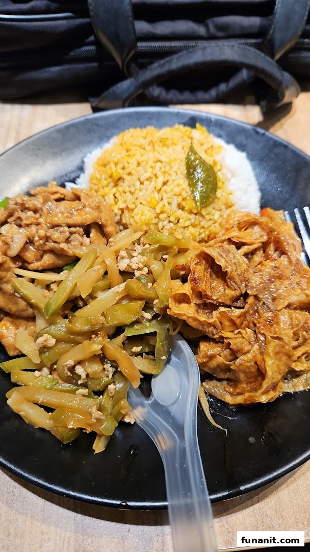 A plate of mixed vegetable rice with various toppings and a plastic fork.