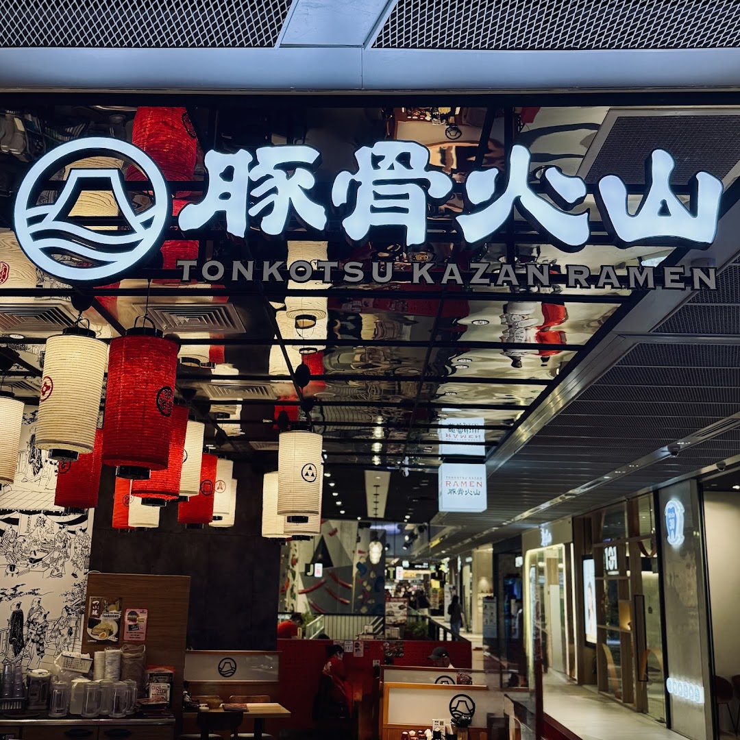 The illuminated entrance of Tonkotsu Kazan Ramen, featuring traditional Japanese lanterns and a view into the mall corridor.