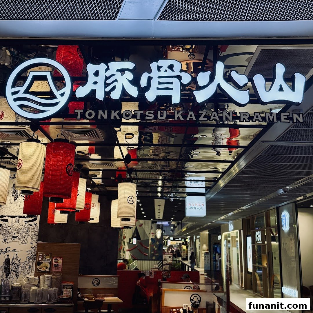 The illuminated entrance of Tonkotsu Kazan Ramen, featuring traditional Japanese lanterns and a view into the mall corridor.