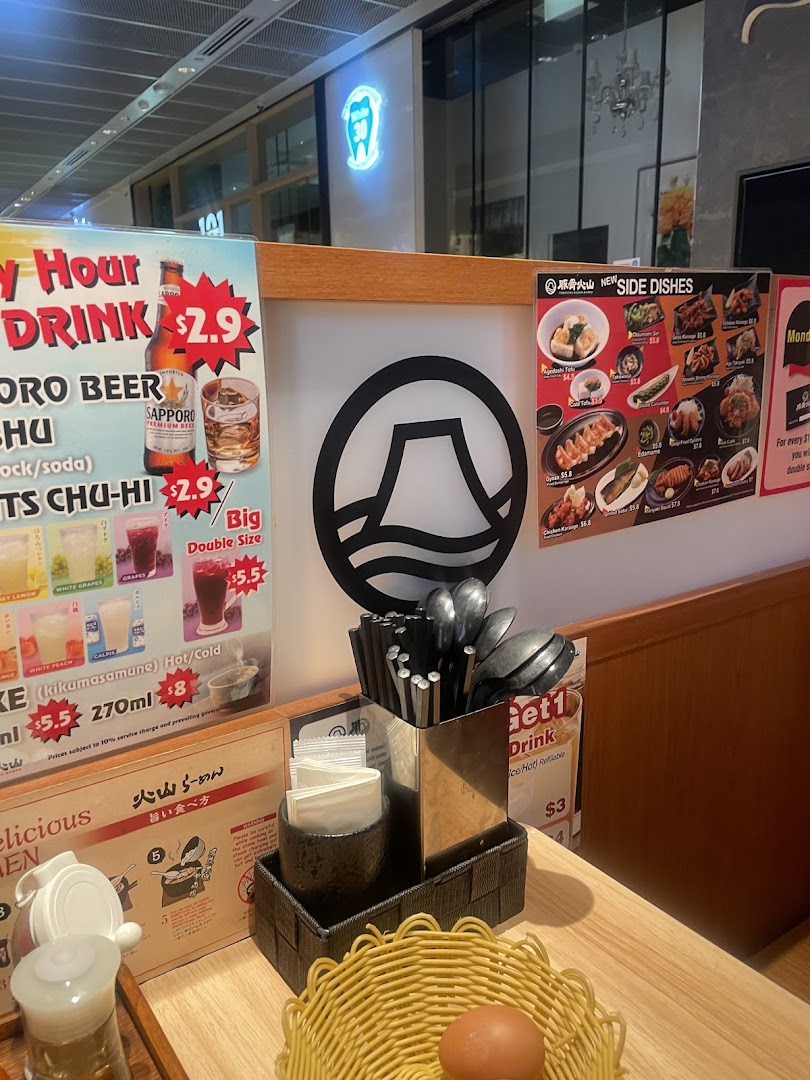 An interior shot of Tonkotsu Kazan Ramen, showing a table setting with various menus and condiments.
