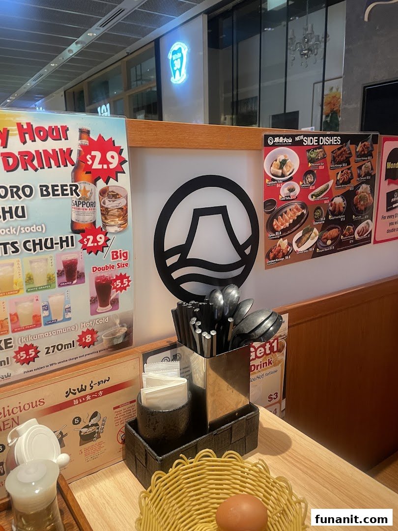 An interior shot of Tonkotsu Kazan Ramen, showing a table setting with various menus and condiments.