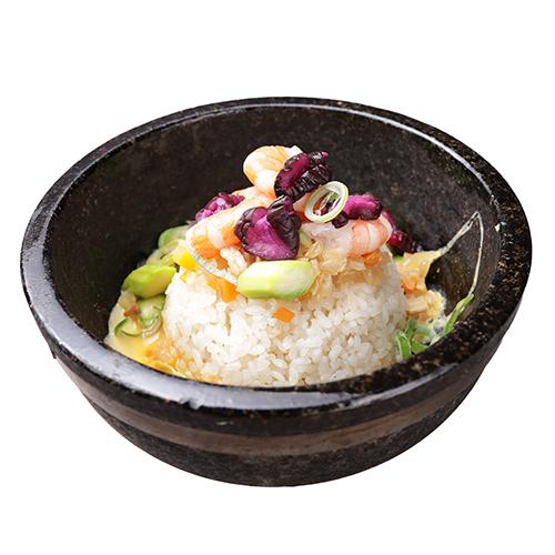 A vibrant seafood and vegetable rice bowl served in a dark stone bowl.