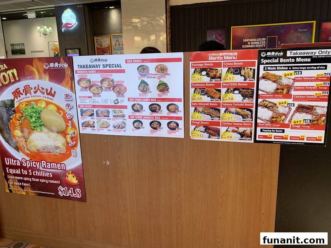 The entrance of Tonkotsu Kazan VOLCANO Ramen, featuring large promotional menus and a spicy ramen poster.