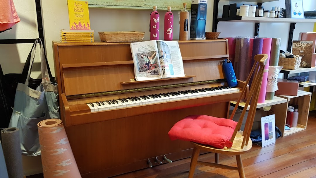 Interior view of Touch The Toes, showcasing yoga mats, wellness products, and a piano.