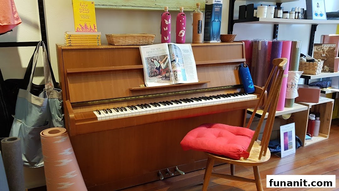 Interior view of Touch The Toes, showcasing yoga mats, wellness products, and a piano.