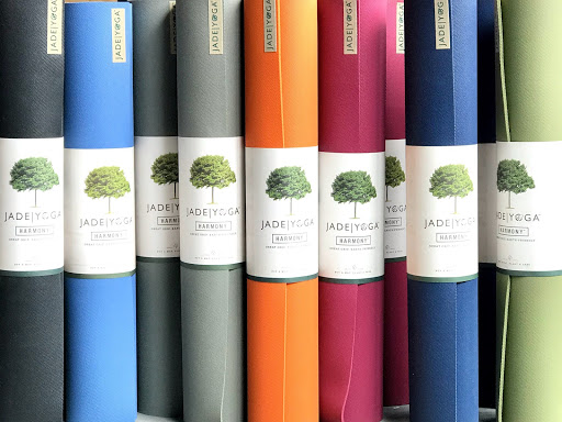 A vibrant display of colorful Jade Yoga Harmony mats, showcasing the shop's diverse product range.