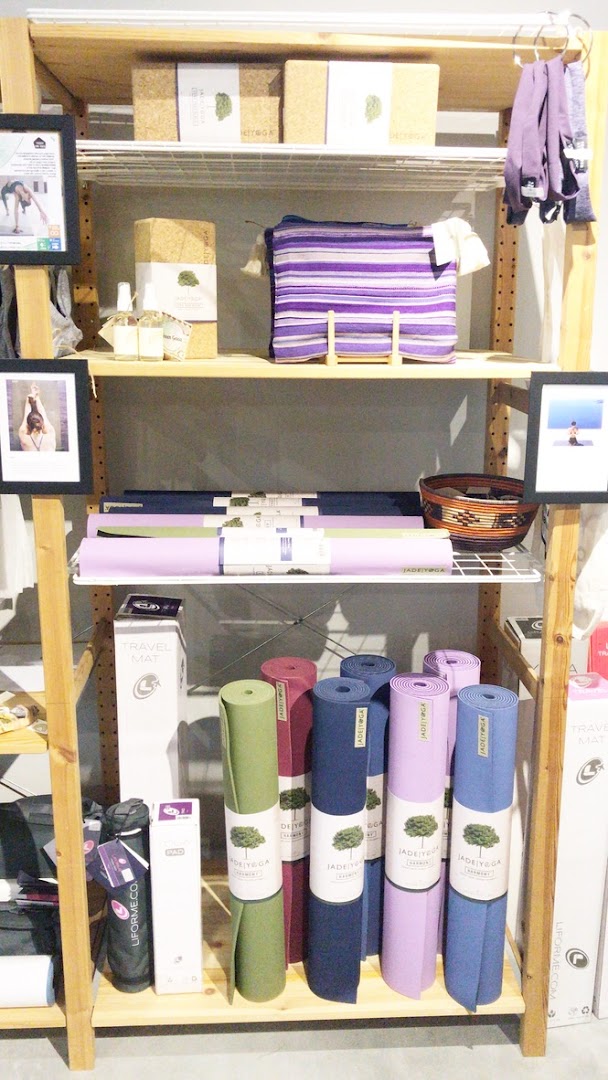 A retail display shelf showcasing various yoga mats, cork blocks, and wellness accessories.