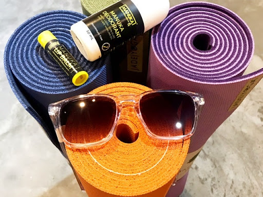 Colorful yoga mats, sunglasses, and wellness products like lip balm and deodorant, ready for a healthy lifestyle.
